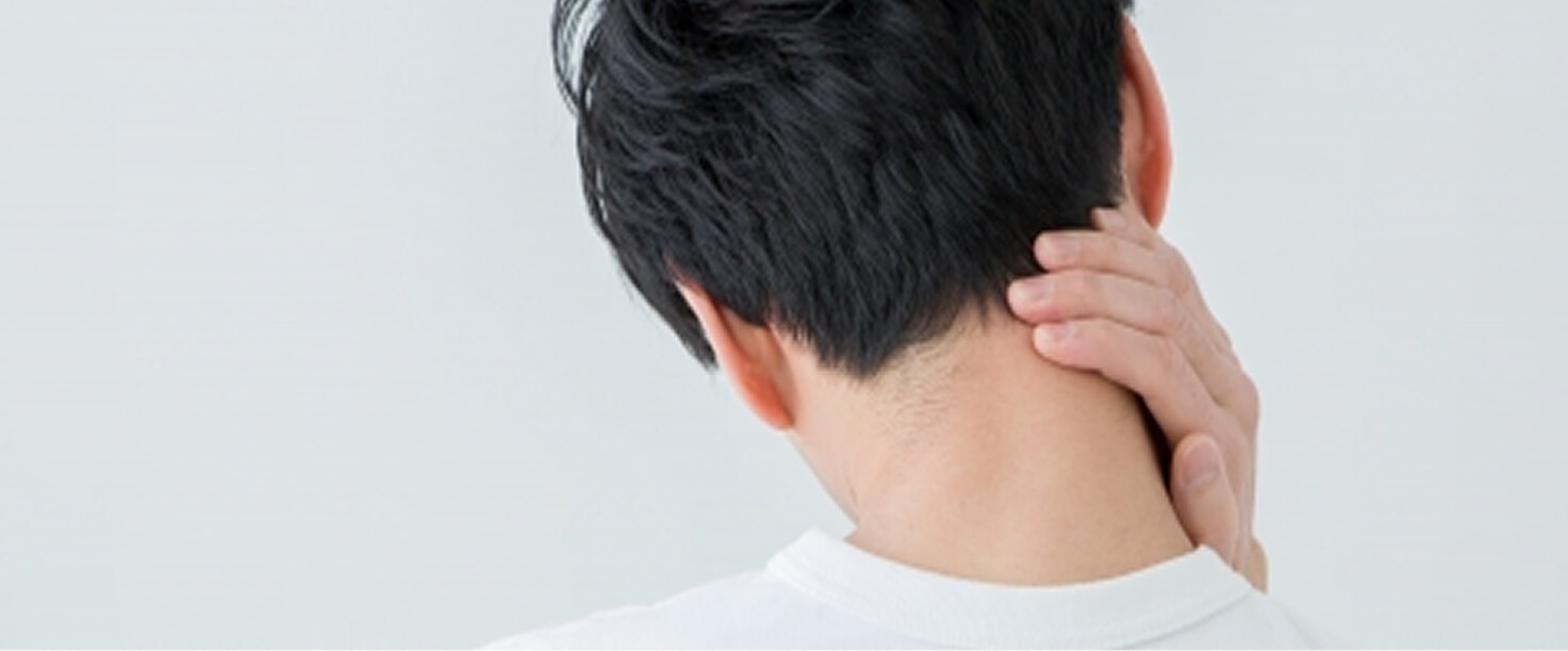 首の後ろを手で押さえる男性