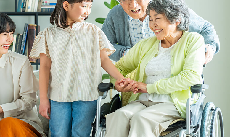 車いすの高齢の女性と家族