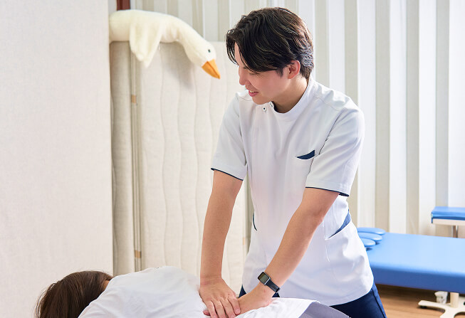 ベッドで腰の施術を受ける女性